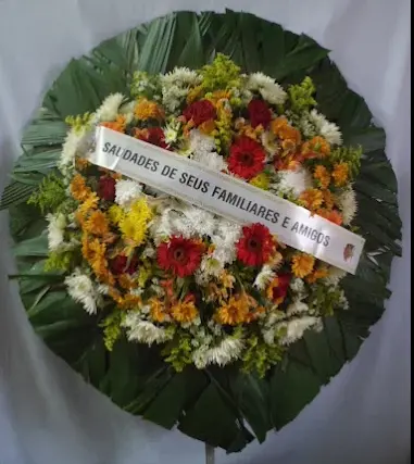 Coroa de flores coloridas com faixa de homenagem